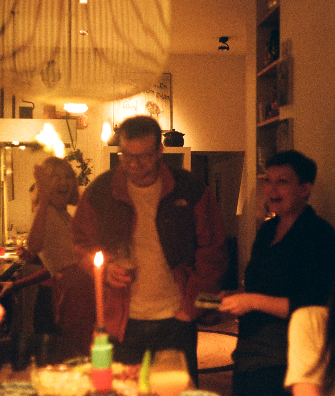 Eine Runde Freunde bei Kerzenlicht in einer Wohnung